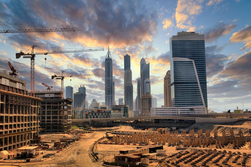 Dubai construction projects taking shape with cranes and skyscrapers in the background of new building foundations.