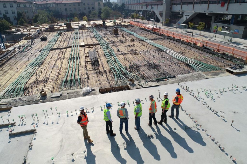 Construction site managed by one of the largest construction companies in the world, with workers in safety gear inspecting the progress.