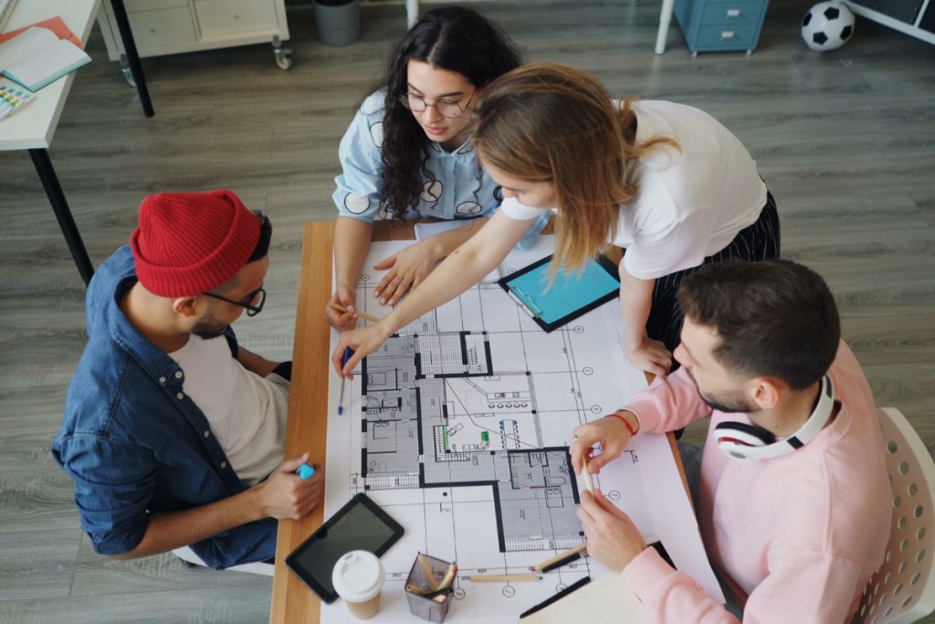 Project team reviewing architectural drawings together during a BIM coordination meeting to improve collaboration and resolve design issues.